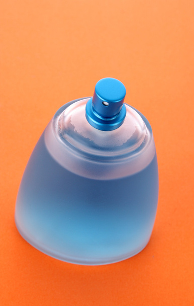 Blue perfume bottle with orange background - Φωτογραφία, εικόνα