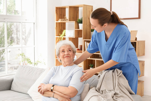Senior woman with female caregiver at home - Photo, Image