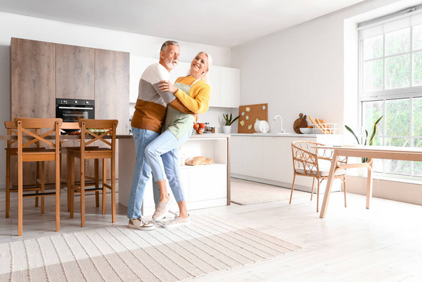 Mature couple dancing in kitchen - Photo, Image