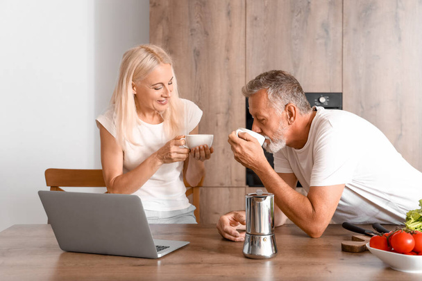 Зрелая пара пьет кофе на кухне - Фото, изображение