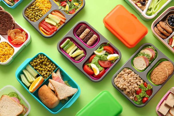 Many lunchboxes with different delicious food on green background - Photo, Image