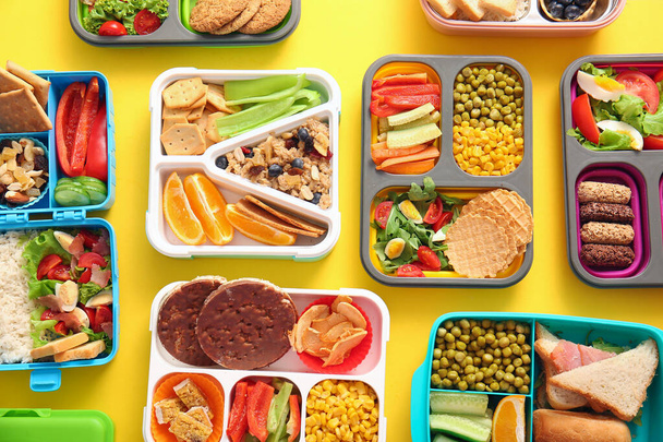 Molti cestini da pranzo con diversi cibi deliziosi su sfondo giallo - Foto, immagini