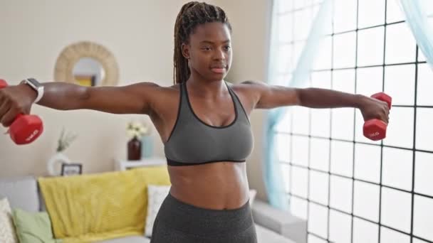 Mujer afroamericana usando mancuernas de entrenamiento en casa - Metraje, vídeo