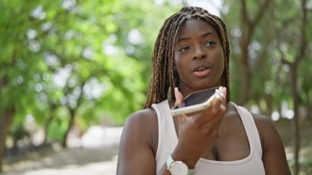 Αφροαμερικανή γυναίκα στέλνει φωνητικό μήνυμα με smartphone στο πάρκο - Πλάνα, βίντεο