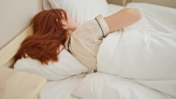 Νεαρή κοκκινομάλλα ξαπλωμένη στο κρεβάτι κοιμάται στο υπνοδωμάτιο - Πλάνα, βίντεο