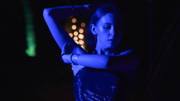 Молодая женщина танцует на фоне светящихся фонарей. Высокое качество фото - Фото, изображение
