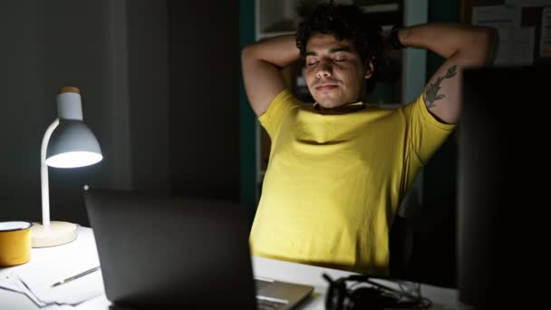 Trabajador de negocios joven latino usando portátil estirando brazos en la oficina - Metraje, vídeo