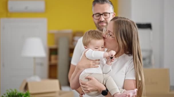 Rodina matky, otec a dítě líbání v novém domově - Záběry, video