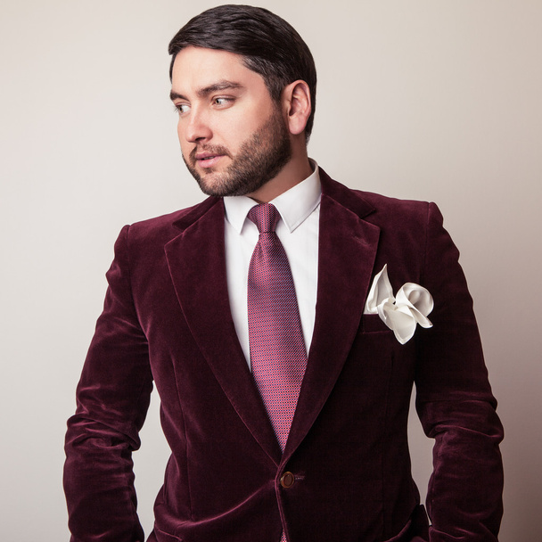 Elegant young handsome man in luxury velvet claret costume. Studio fashion portrait. - Photo, Image