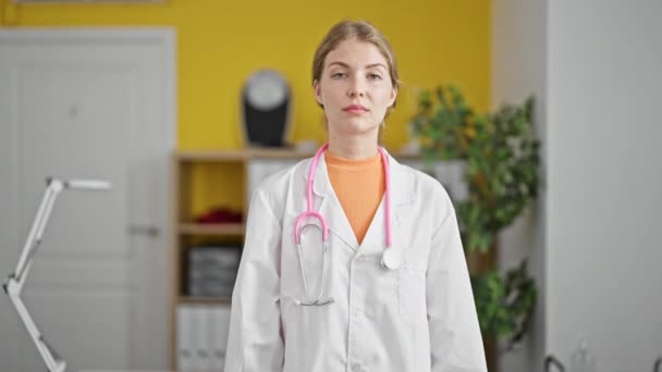 Νεαρή ξανθιά γυναίκα γιατρός κάνει τον αντίχειρα επάνω στην κλινική - Πλάνα, βίντεο