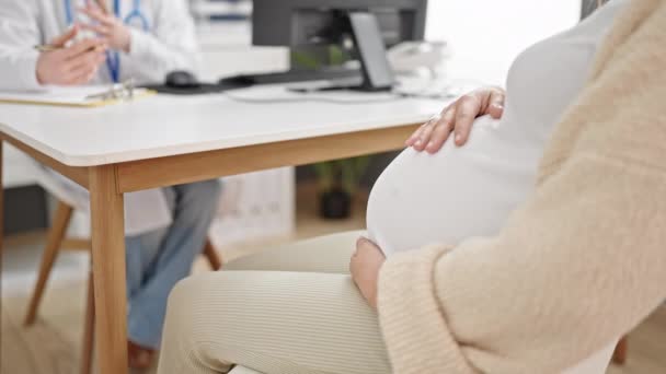 Νεαρή έγκυος γυναίκα γυναικολόγος και ασθενής που έχει ιατρική γνωμάτευση στην κλινική - Πλάνα, βίντεο