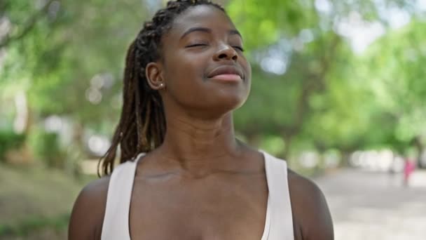 afroamericano donna sorridente fiducioso respirazione a parco - Filmati, video
