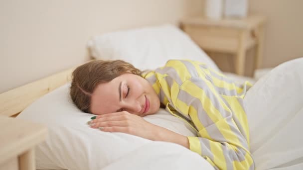 Νεαρή ξανθιά γυναίκα ξαπλωμένη στο κρεβάτι κοιμάται στο υπνοδωμάτιο - Πλάνα, βίντεο