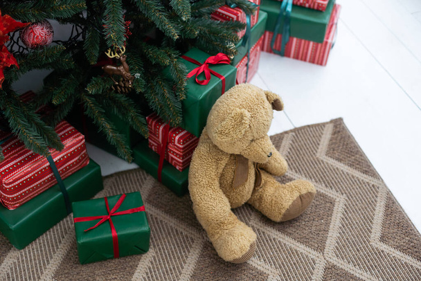Gyönyörű karácsonyi ajándékok fenyőfa alatt a padlón a szobában - Fotó, kép