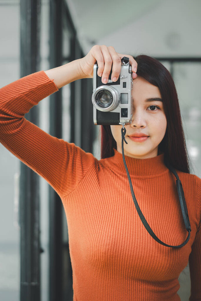 Hipster woman taking photos with retro film camera on the field. - Photo, Image
