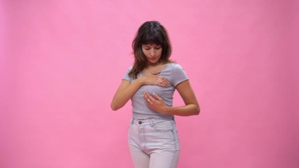 Vrouw doet een Borst Self-Examen het controleren van de borst verandert over roze achtergrond. - Video