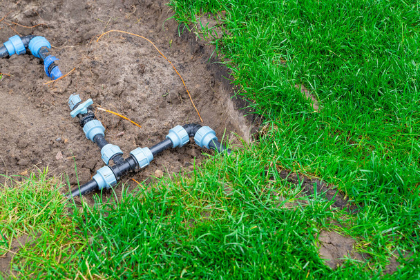 Tubos de plástico e fiação de circuito para irrigação de gramado. Conexão acessórios e válvulas para desligar a água no jardim - Foto, Imagem