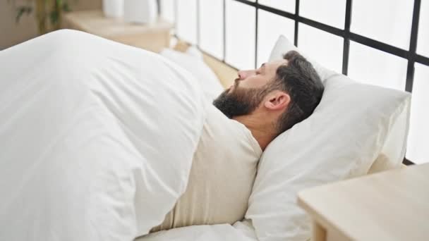 jonge latino man liggend op bed slapen in slaapkamer - Video