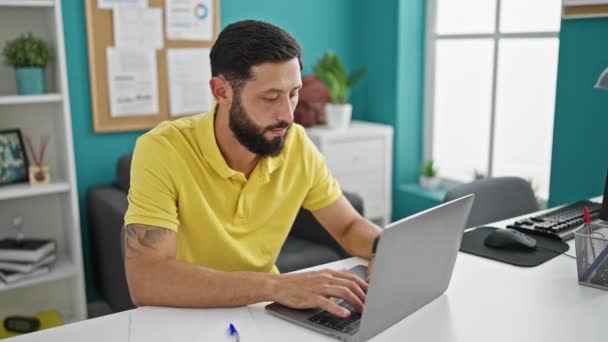 Fiatal spanyol férfi üzleti dolgozó laptoppal fáradt az irodában - Felvétel, videó