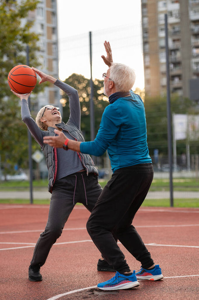 mulher sênior e homem maduro jogando basquete no parque - Foto, Imagem