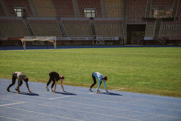 Three friends are about to run a marathon around the stadium - Photo, Image