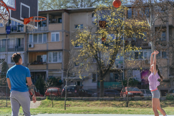 Deportes chica tomando 2 puntos tiro al jugar baloncesto con su amigo varón - Foto, Imagen