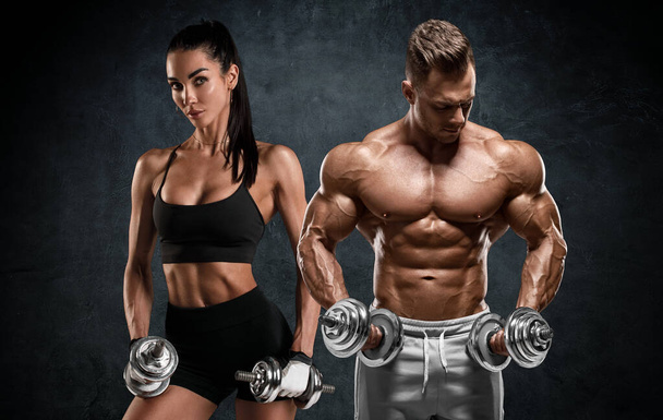 Спортивная пара тренировок с гантелями. Мускулистые мужчина и женщина показывают мышцы - Фото, изображение