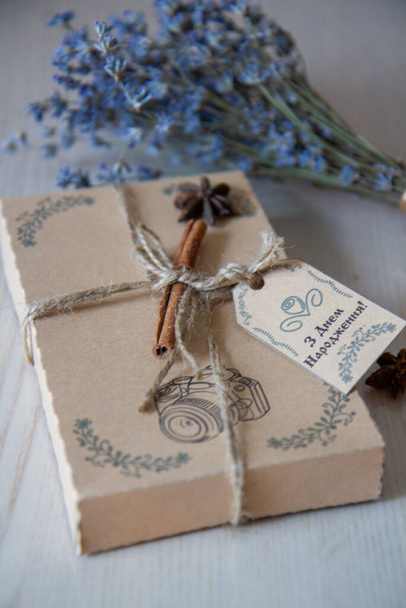 hnědá dárková krabička se skořicovou tyčinkou a kyticí levandule, nápis "Všechno nejlepší k narozeninám" - Fotografie, Obrázek