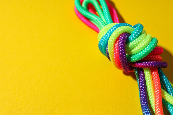 Un nœud de lacets multicolores sur fond jaune. Place pour le texte - Photo, image