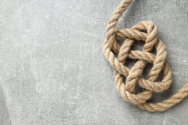 Knotted thick rope close-up on gray background. Place for text - Photo, Image