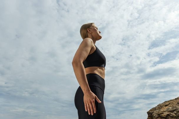Спортивная девушка, блондинка, на открытом воздухе, спортивное телосложение - Фото, изображение