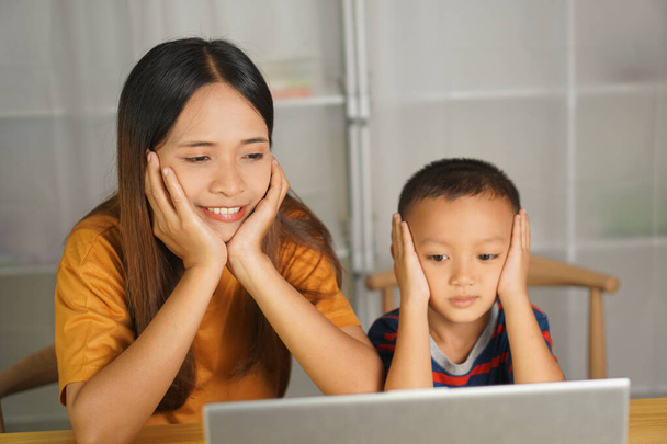 moeder en zoon kijken films op de computer thuis tafel - Foto, afbeelding