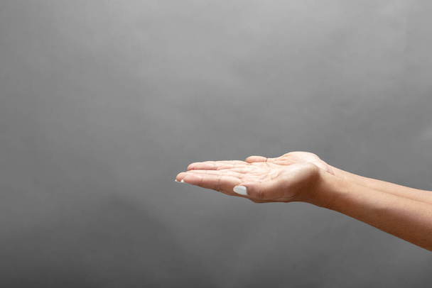 Жіноча рука на сірому фоні, що показує різні вирази або емоції. - Фото, зображення
