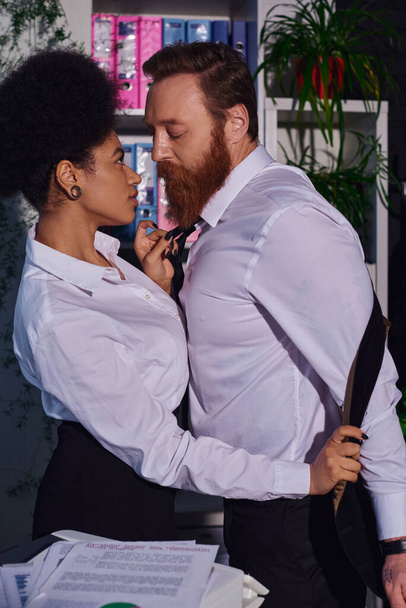 tempting african american businesswoman undressing bearded colleague in office, side view - Foto, immagini