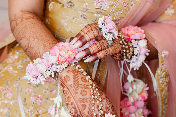 As mãos de uma noiva indiana são decoradas com flores e padrões de henna de estilo indiano. Mãos da noiva close-up com padrões e ornamentos em estilo indiano tradicional vista superior - Foto, Imagem
