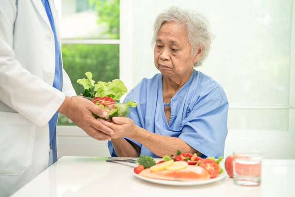 Aziatische oudere vrouw patiënt eten zalm steak ontbijt met groente gezond voedsel in het ziekenhuis. - Foto, afbeelding