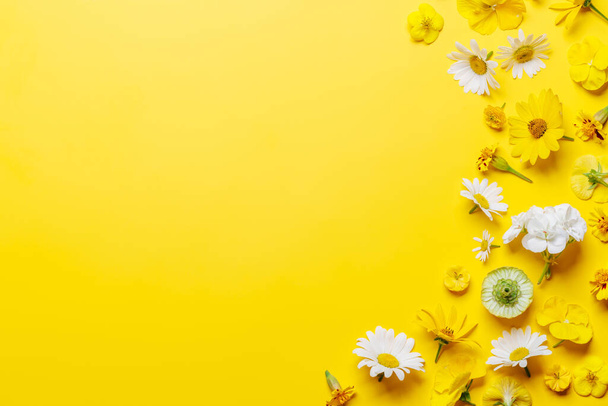 Assorted flowers on yellow backdrop, a vibrant display with space for text. Flat lay - Photo, Image