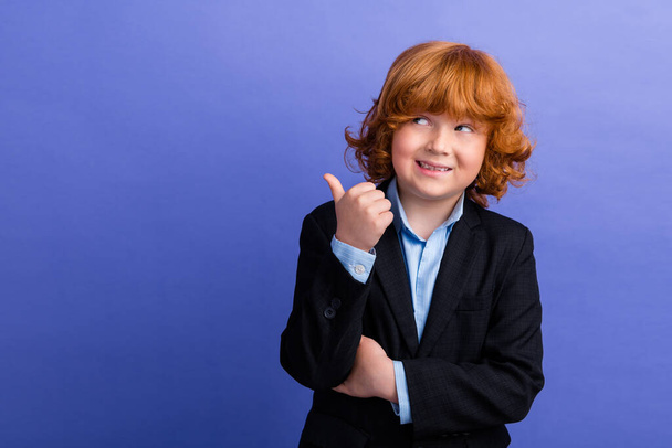 Portrait of cheerful little schoolkid beaming smile look direct thumb finger empty space isolated on purple color background. - Foto, imagen
