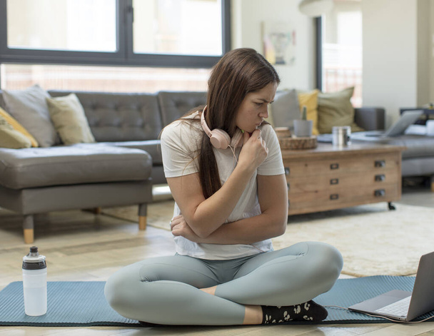 young adult woman practicing yoga feeling confused or doubting, concentrating on an idea, thinking hard, looking to copy space on side - Fotoğraf, Görsel