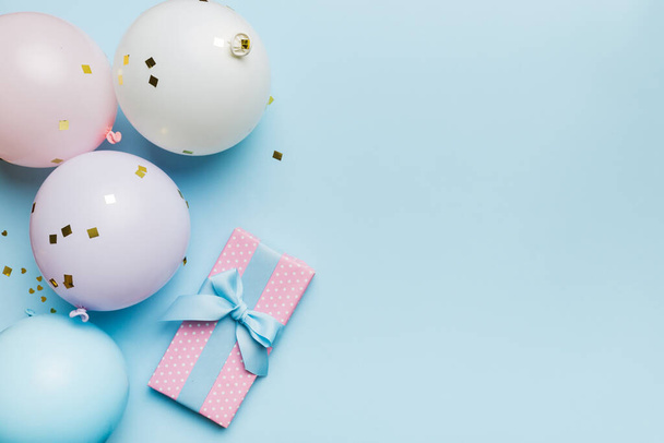 Fond de vacances avec ballon coloré, cadeau et confettis. Style à plat. Carte de vœux anniversaire ou fête avec espace de copie. - Photo, image