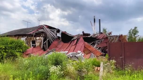 Ukrayna 'nın bir köyünde top mermisi ile yıkılan bir ev. Yıkık çatılı bir ev, molozların altından bacalar görünüyor. Rus-Ukrayna savaşı, gerçek savaş. - Video, Çekim