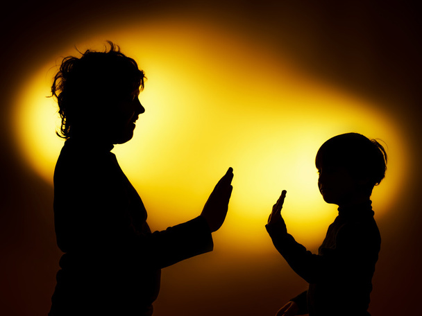 Gesticu kullanarak duygular gösterilen iki anlamlı çocuğun siluetleri - Fotoğraf, Görsel