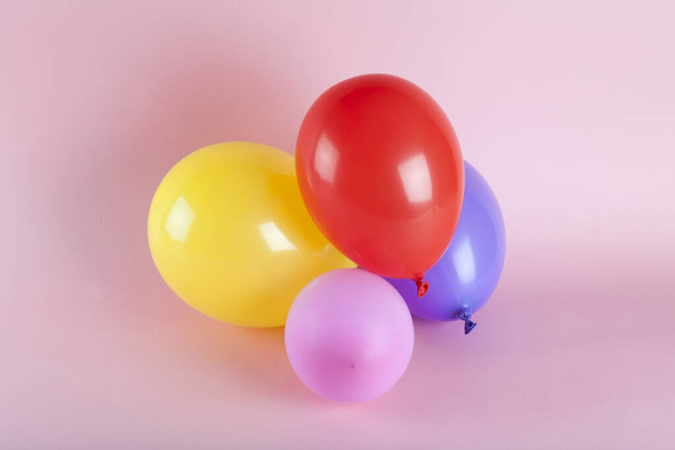 μπαλόνια σε αρμονικά χρώματα σε ροζ φόντο. Minimal χρώμα νεκρές φύσεις. - Φωτογραφία, εικόνα