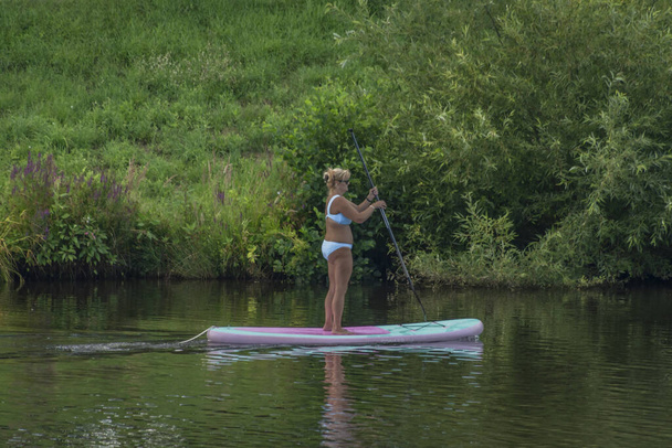 Paddle board con deportistas en verano día soleado en el río Moldava en Budweis CZ 07 31 2023 - Foto, imagen