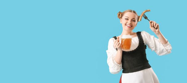 Piękna kelnerka Octoberfest z piwem i kiełbasą na jasnoniebieskim tle z miejscem na tekst - Zdjęcie, obraz