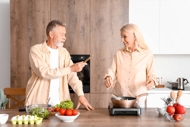 Couple mature avec des épices cuisine dans la cuisine - Photo, image