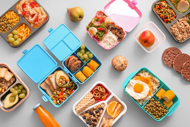 Many lunchboxes with different delicious food on grey background - Photo, Image
