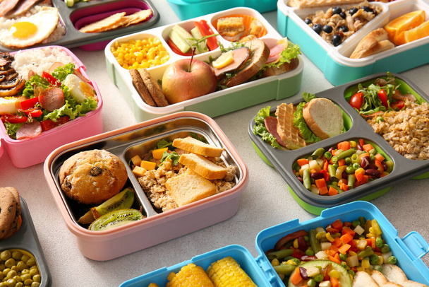 Many lunchboxes with different delicious food on light background - Photo, Image