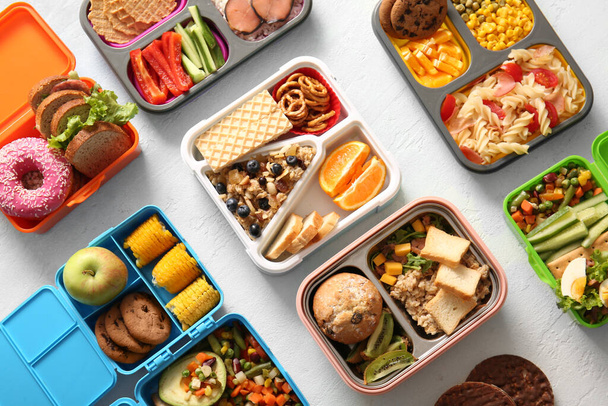 Lunchboxes with different delicious food on gradient background - Photo, Image