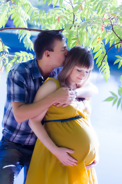 Happy and young pregnant couple on nature - Photo, Image